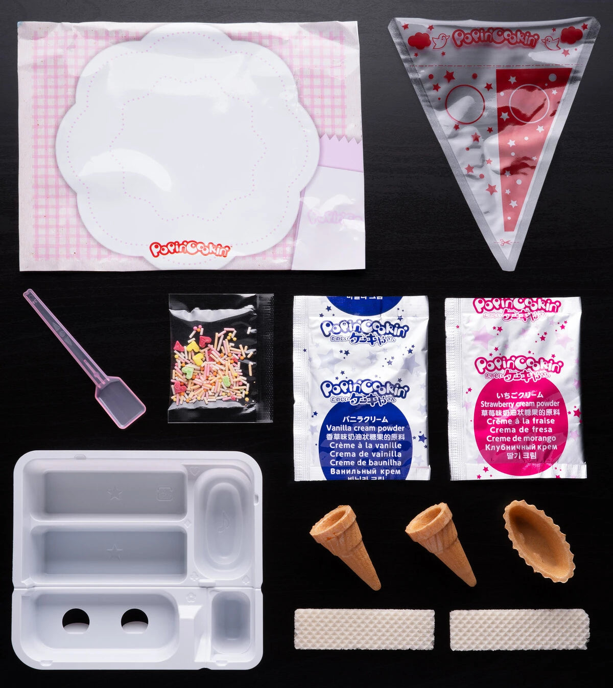 Contents: tray, spoon, squeezing bag, 2 cones, 1 tarte shell, 2 wafers, sugar sprinkles, and 2 ingredient packets.