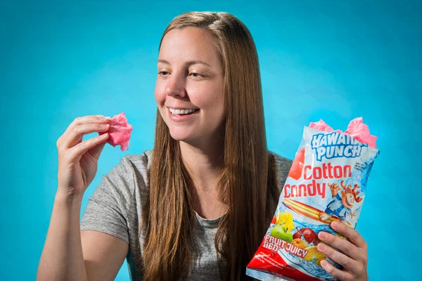 A woman holds a bag of Hawaiian Punch Cotton Candy