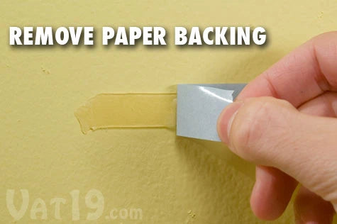 Step 2: Remove the paper backing to reveal the other sticky side of tape.