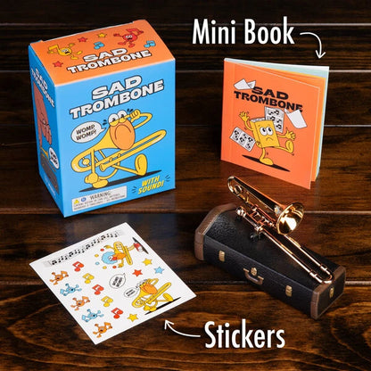 The Sad Trombone Kit includes a set of stickers (for the case), a mini book, and the hilarious trombone itself.